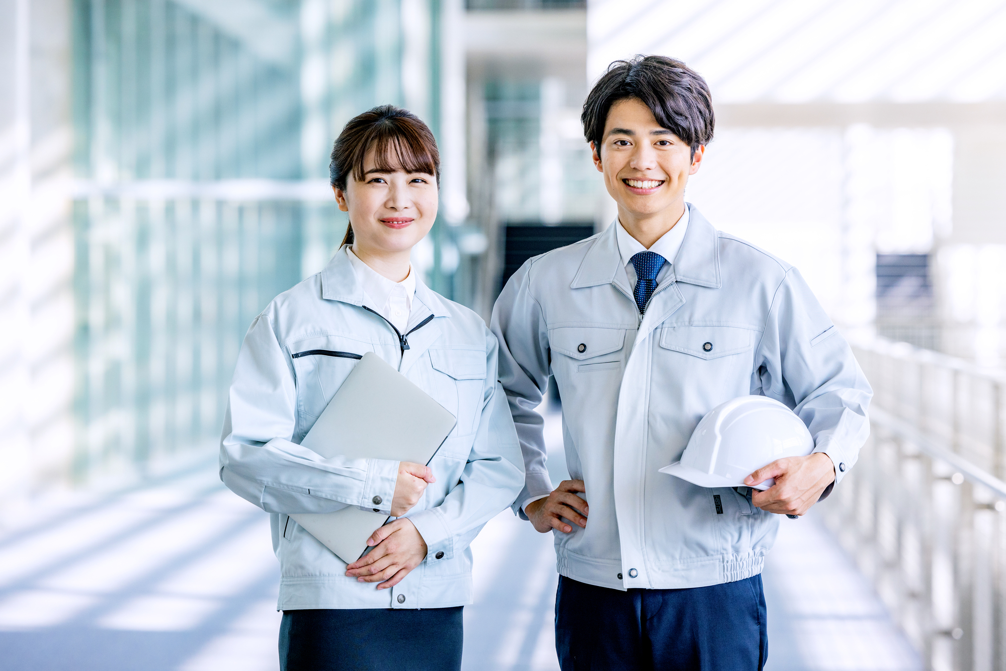作業服を着てヘルメットを抱える男性